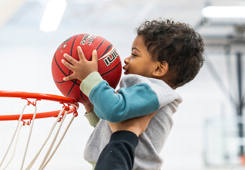 A baby dunking a basketball