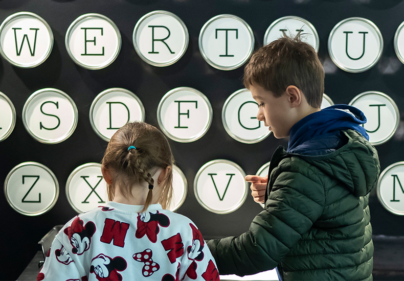 Two children interacting with the typewriter in the What's Your Type exhibit at the Oakville Museum on Family Day 2024. 