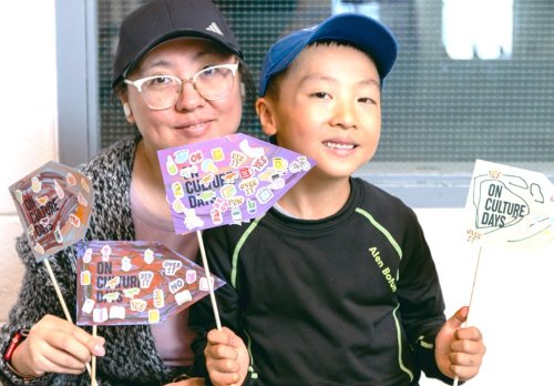 Parent and Child holding Culture Days flags 