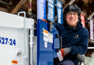 A facility services staff driving the ice resurfacer.