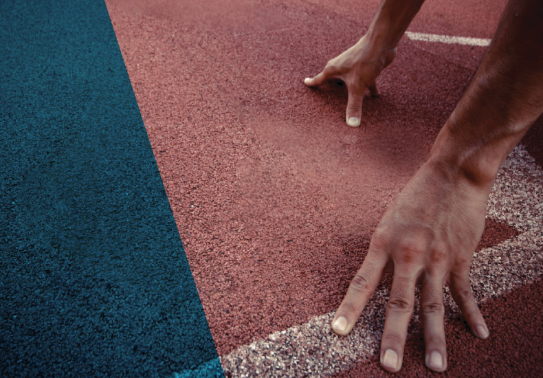 Close up of a runner's hands on the track at the start line