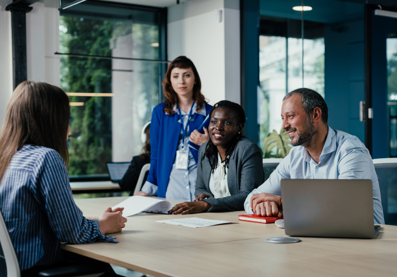 Group of people sitting at a board table in an interview set-up.