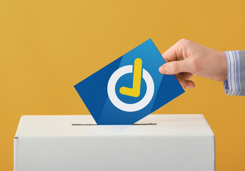 Hand placing a ballot with a checkmark in a ballot box