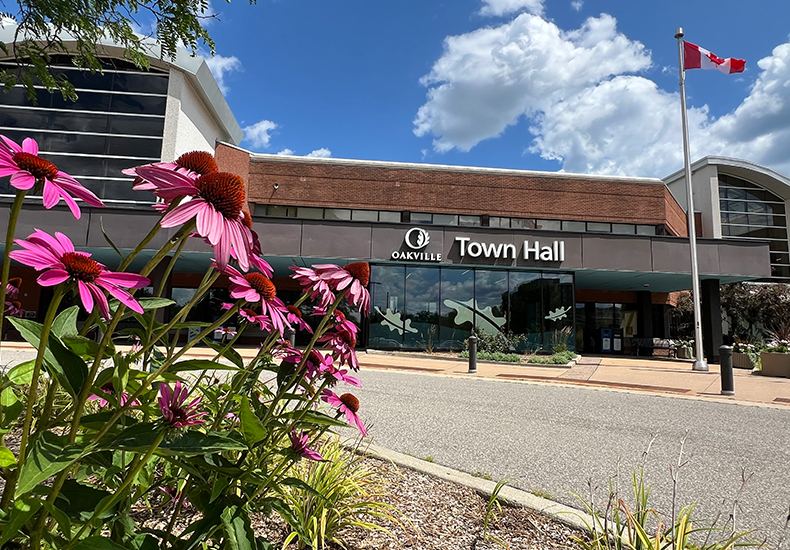 Public entrance at the front of Oakville Town Hall in the summer, with pink coneflowers in the foreground.